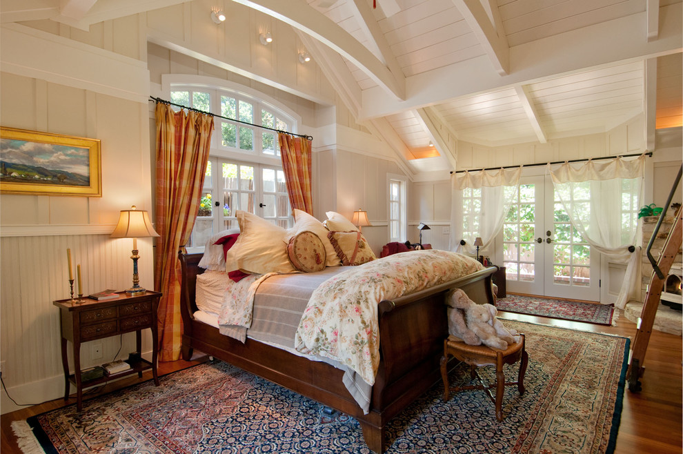 Aménagement d'une chambre d'amis classique de taille moyenne avec un mur beige, un sol en bois brun, une cheminée d'angle et un manteau de cheminée en pierre.