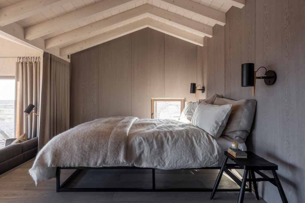 エセックスにあるビーチスタイルのおしゃれな寝室 (茶色い壁、濃色無垢フローリング、茶色い床、表し梁、三角天井、板張り天井、板張り壁) のインテリア