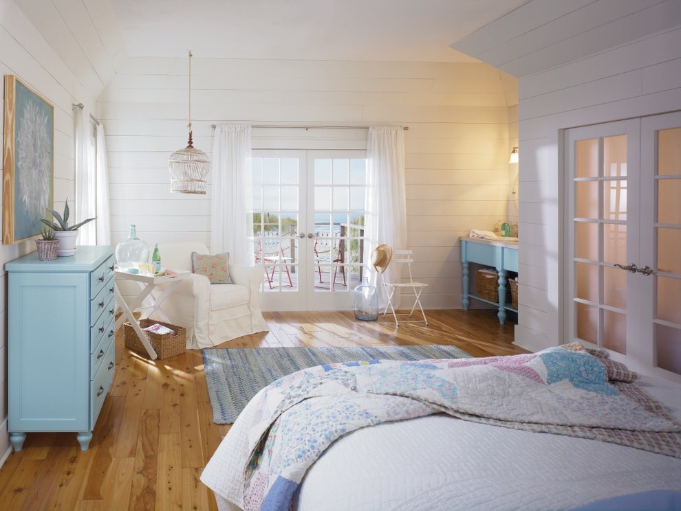 Imagen de dormitorio costero con paredes blancas y suelo de madera clara