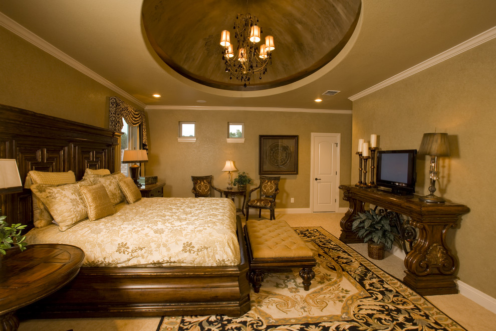Example of a large tuscan master carpeted bedroom design in Austin with beige walls and no fireplace