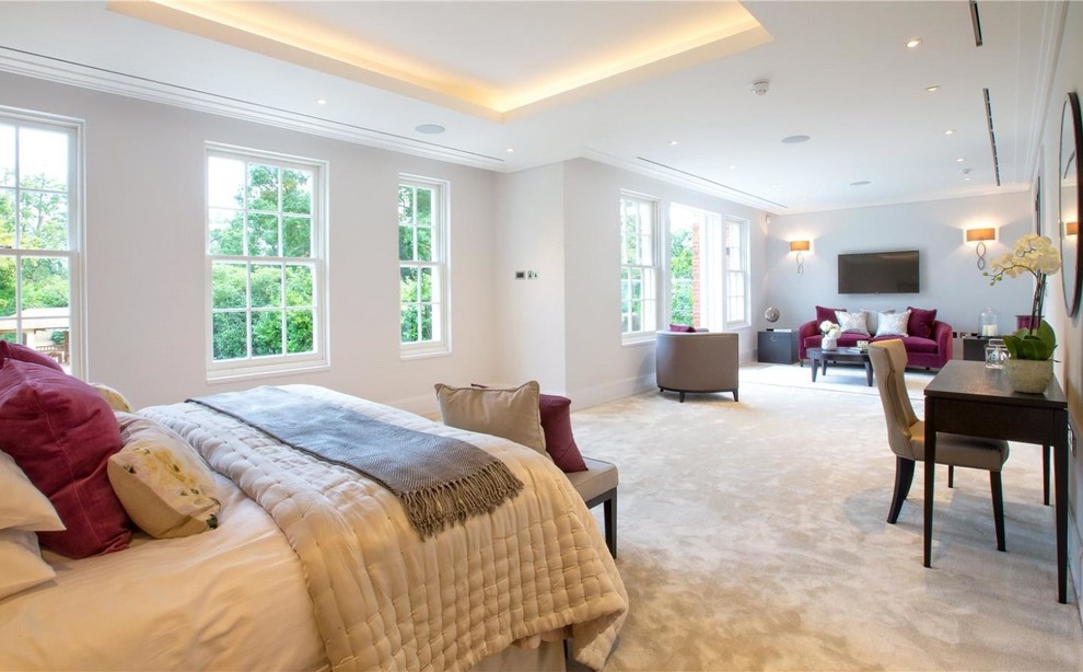 Inspiration for a large traditional master bedroom in London with white walls and carpet.