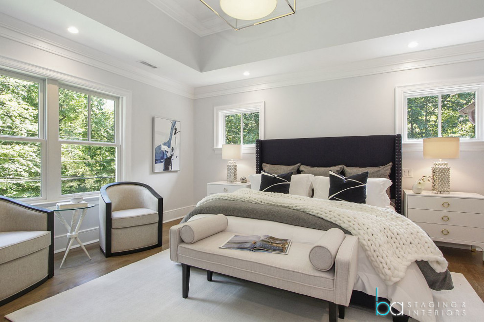 Idée de décoration pour une chambre parentale design de taille moyenne avec un mur blanc, un sol en bois brun et un sol marron.