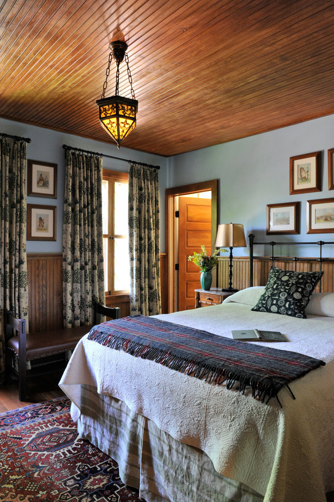 Immagine di una camera matrimoniale stile rurale di medie dimensioni con pareti blu e parquet scuro