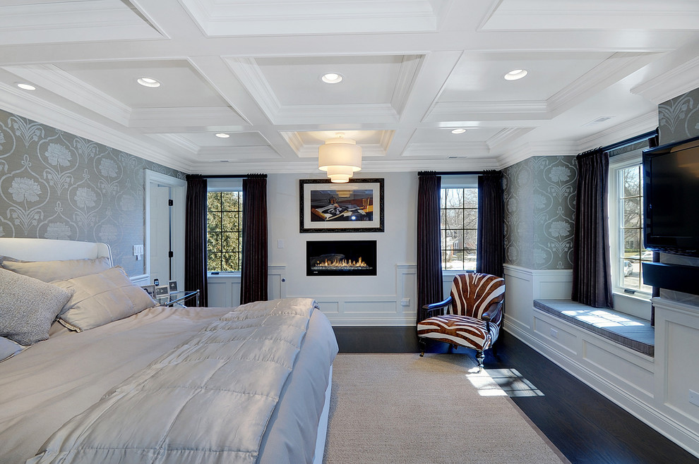 Стильный дизайн: большая хозяйская спальня в классическом стиле с белыми стенами, темным паркетным полом, стандартным камином, фасадом камина из штукатурки и коричневым полом - последний тренд