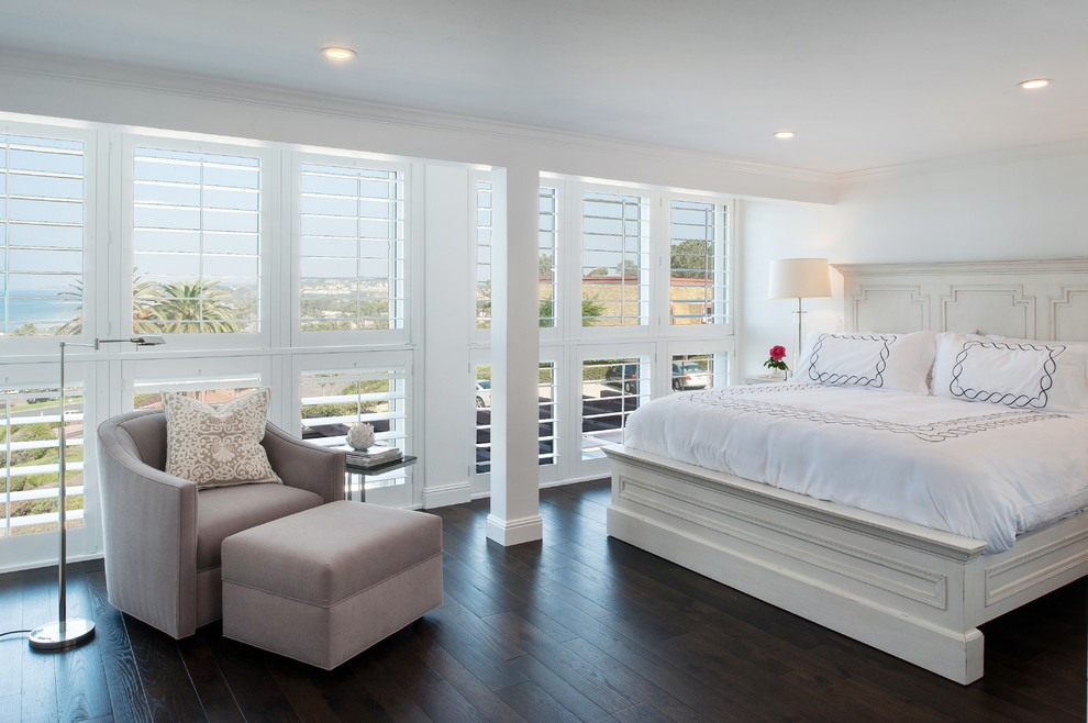 Coastal bedroom in San Diego with white walls and dark hardwood flooring.