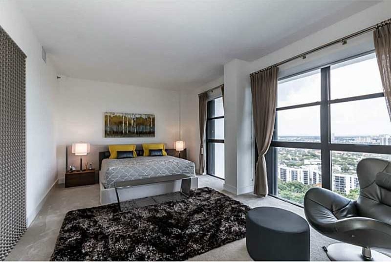 Example of a mid-sized minimalist master carpeted and gray floor bedroom design in Miami with white walls and no fireplace