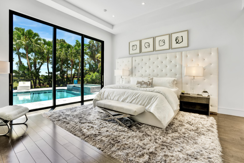 Idee per una camera da letto design con pareti bianche, pavimento in legno massello medio, pavimento marrone e soffitto ribassato