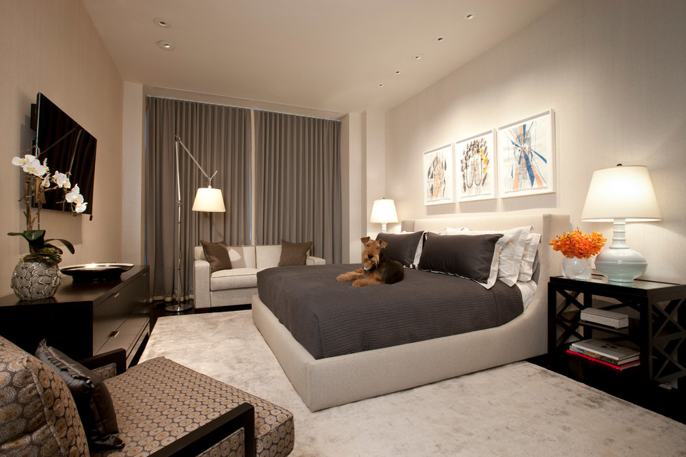 Ejemplo de dormitorio televisión contemporáneo con paredes beige y suelo de madera oscura