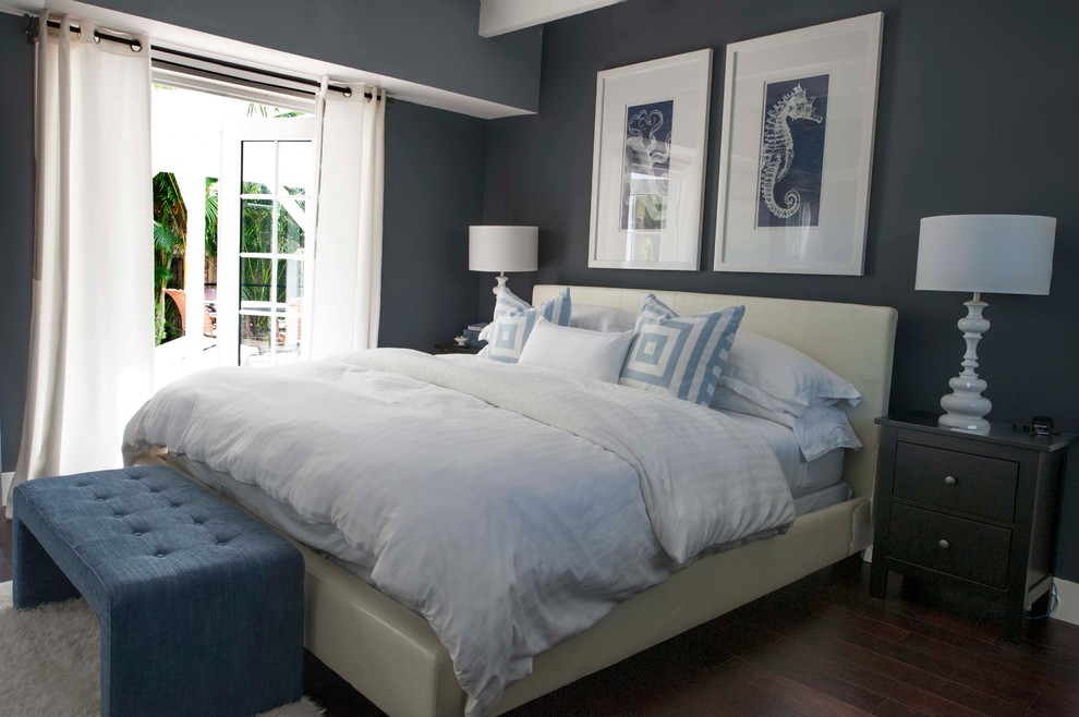 Imagen de dormitorio principal costero pequeño con paredes azules y suelo de madera oscura