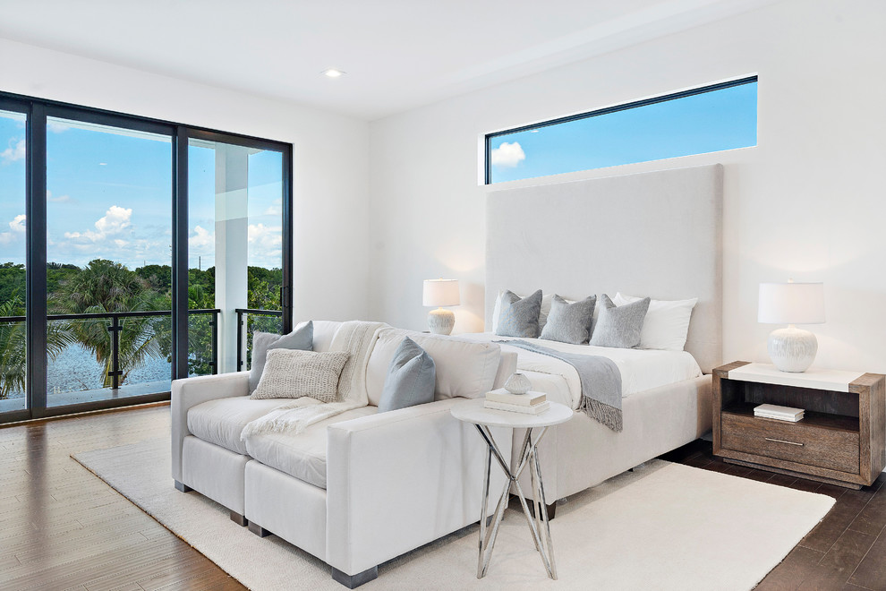 Immagine di una camera da letto costiera con pareti bianche, parquet scuro e pavimento marrone