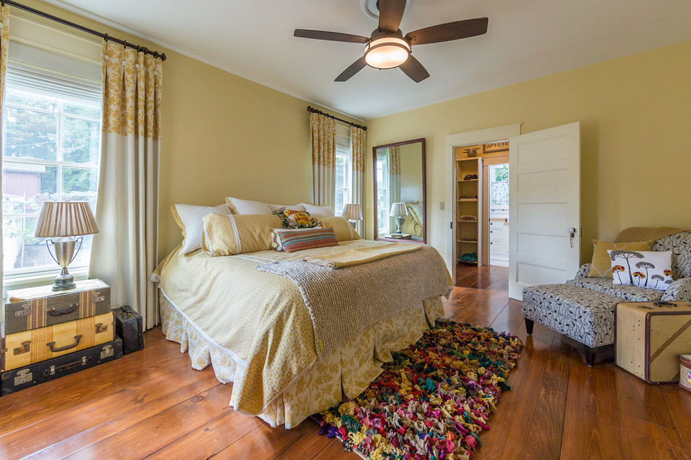 Diseño de dormitorio principal clásico sin chimenea con paredes amarillas y suelo de madera en tonos medios