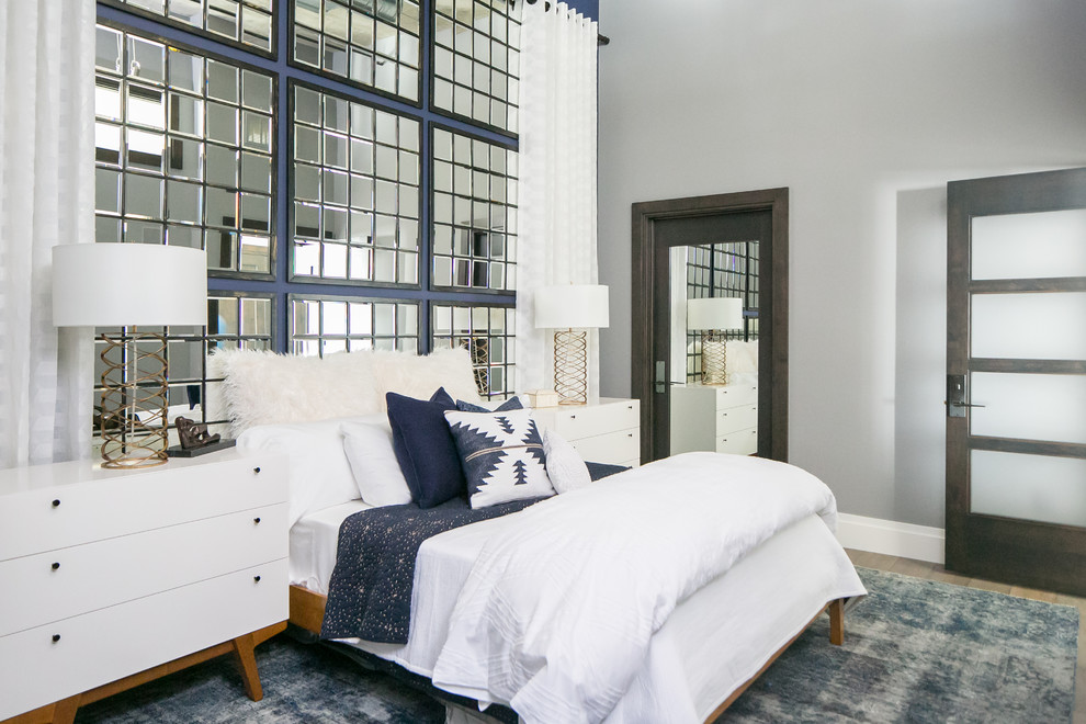 Mittelgroßes Modernes Gästezimmer mit blauer Wandfarbe, braunem Holzboden und grauem Boden in San Diego