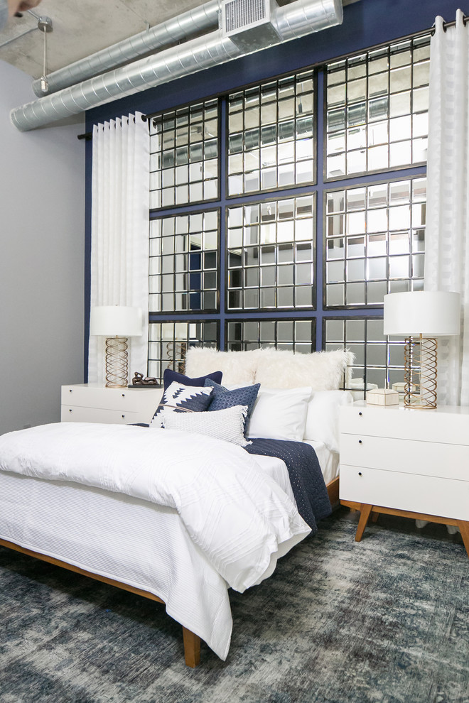 This is an example of a medium sized urban bedroom in Denver with blue walls, medium hardwood flooring and grey floors.