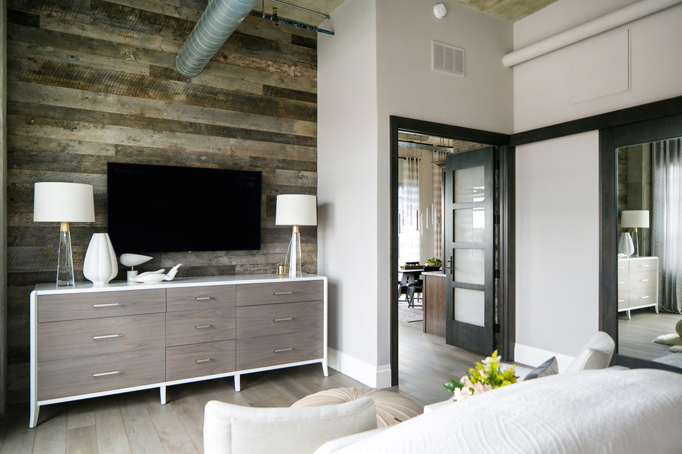 Aménagement d'une chambre parentale industrielle de taille moyenne avec un mur blanc, un sol en bois brun et un sol gris.