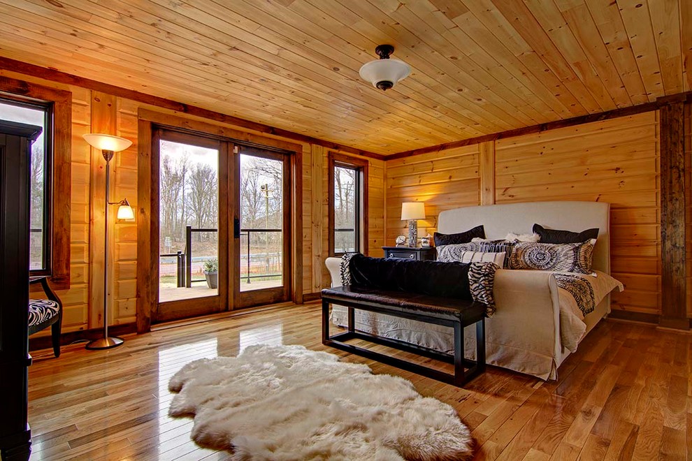 Diseño de dormitorio rústico grande con suelo de madera en tonos medios