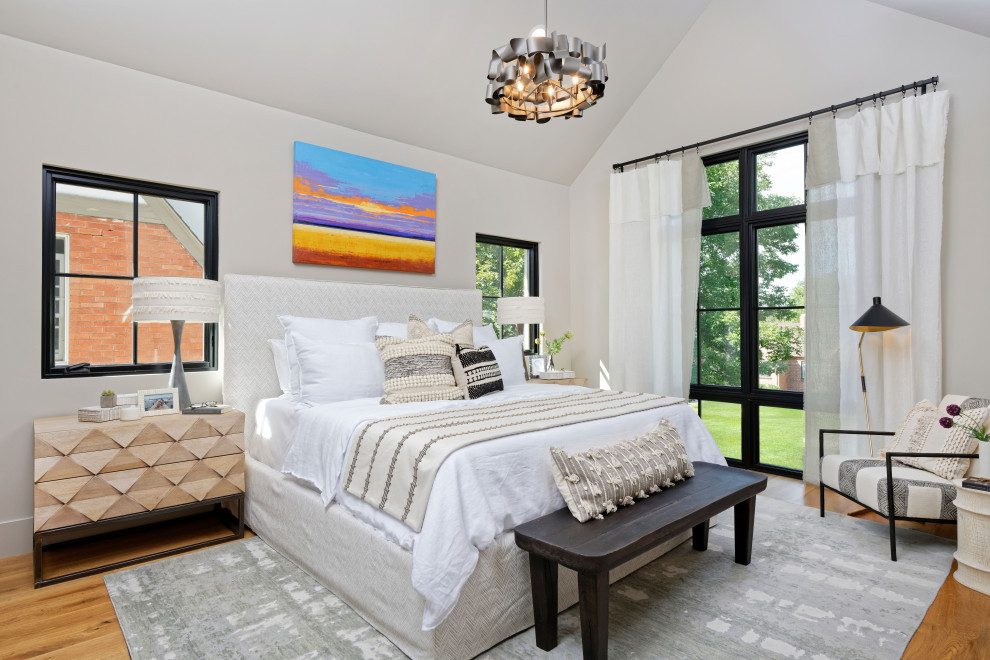 Ejemplo de dormitorio principal y abovedado contemporáneo de tamaño medio sin chimenea con paredes beige y suelo de madera en tonos medios