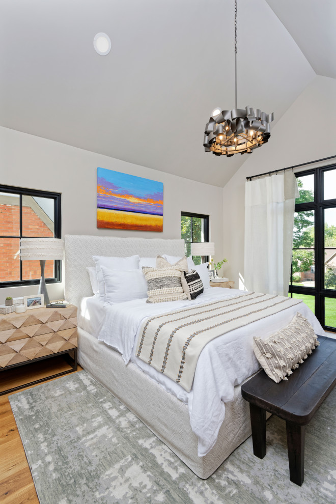 Example of a mid-sized trendy master medium tone wood floor bedroom design in Denver with beige walls and no fireplace
