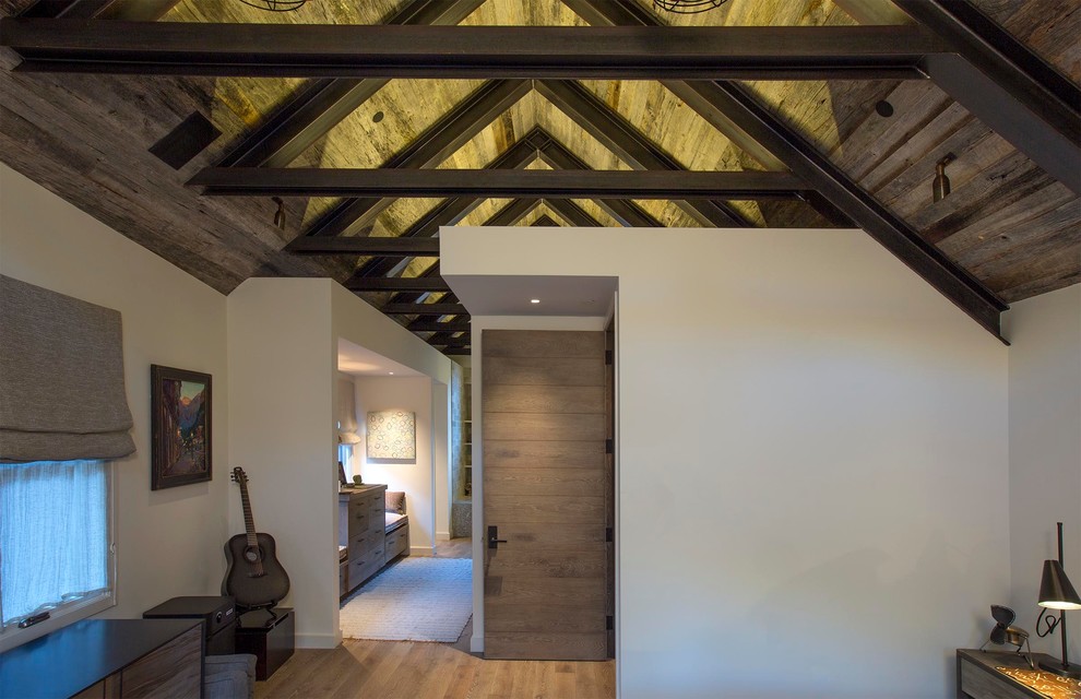 Diseño de dormitorio principal industrial de tamaño medio con paredes blancas y suelo de madera en tonos medios