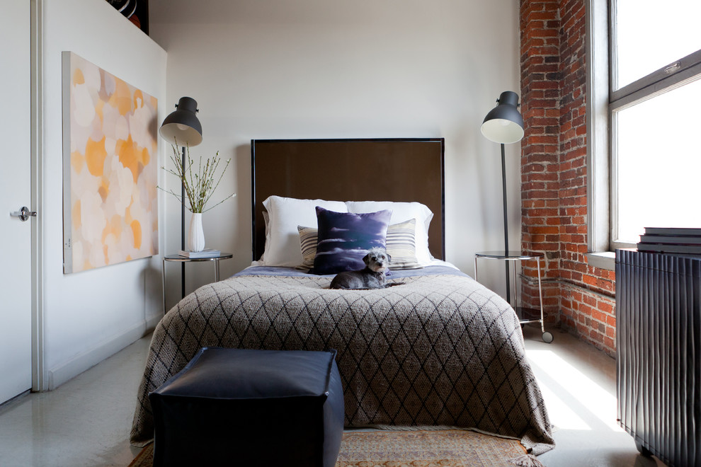 Imagen de dormitorio industrial con paredes blancas y suelo de cemento