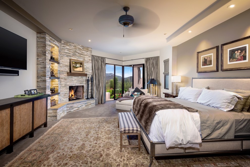 Huge southwest master bedroom photo in Phoenix with beige walls, a standard fireplace and a tile fireplace