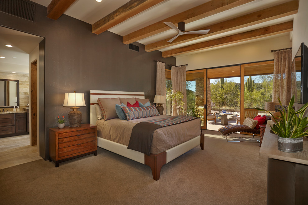 This is an example of a master bedroom in Phoenix with brown walls and carpet.