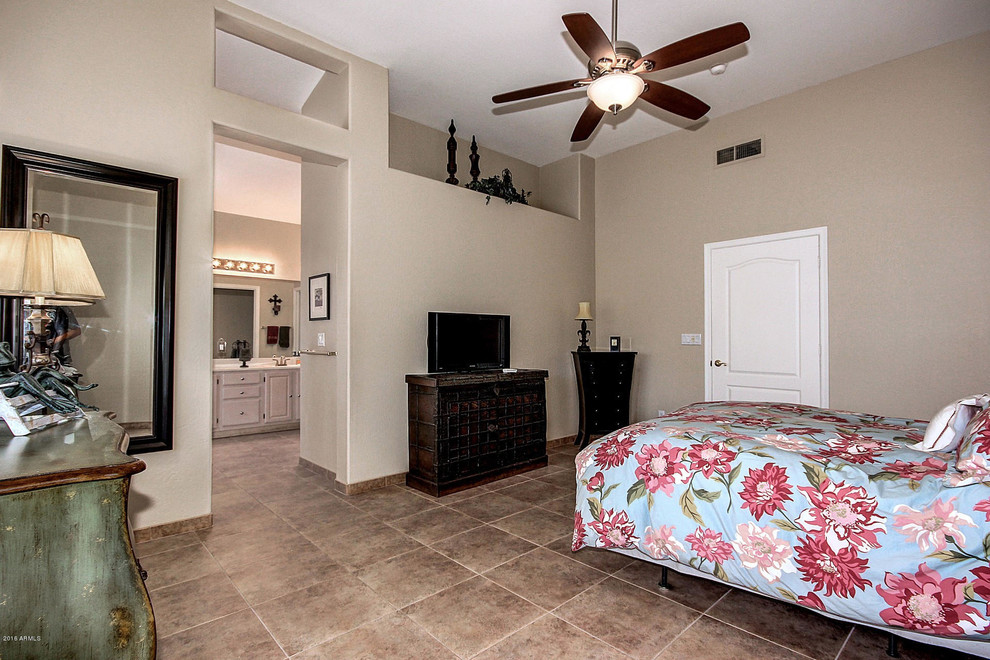 Inspiration for a large mediterranean master bedroom in Phoenix with beige walls and ceramic flooring.