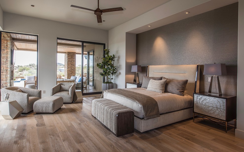 Diseño de dormitorio principal actual grande con suelo de madera en tonos medios, paredes grises y suelo marrón