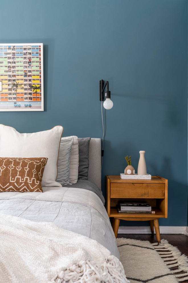 Idée de décoration pour une chambre parentale minimaliste de taille moyenne avec un mur bleu.