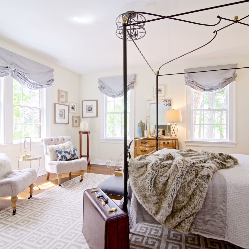 Imagen de dormitorio principal clásico de tamaño medio sin chimenea con paredes blancas, suelo de madera en tonos medios y suelo marrón