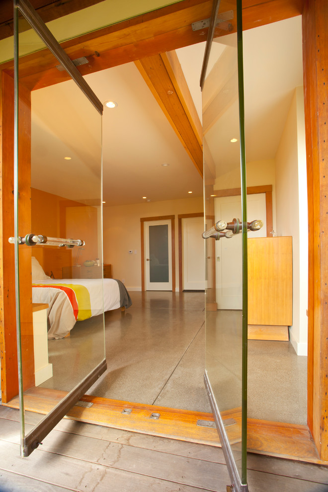 Diseño de dormitorio contemporáneo con suelo de cemento y paredes blancas