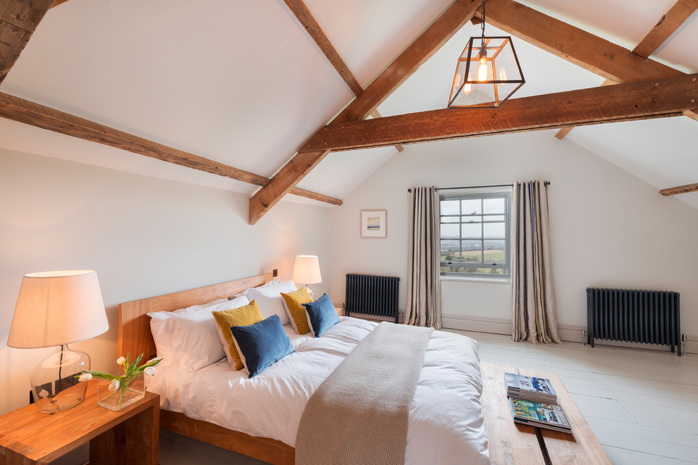 デヴォンにある中くらいなカントリー風のおしゃれな客用寝室 (グレーの壁、塗装フローリング、白い床)