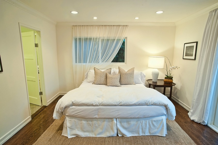 Идея дизайна: спальня в стиле неоклассика (современная классика) с белыми стенами, темным паркетным полом и коричневым полом