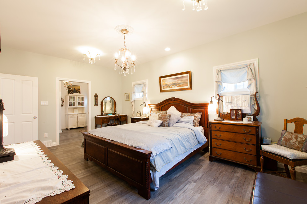 Foto de dormitorio principal clásico grande sin chimenea con paredes blancas, suelo de madera en tonos medios y suelo marrón