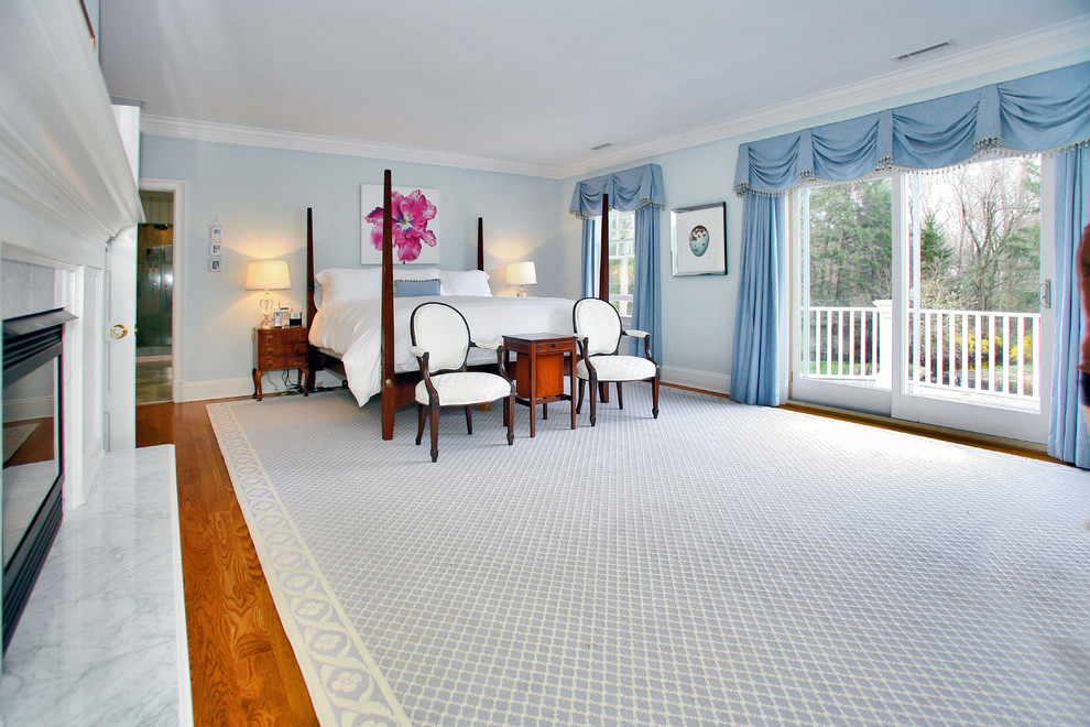 Foto de dormitorio tradicional con paredes azules, suelo de madera en tonos medios y todas las chimeneas