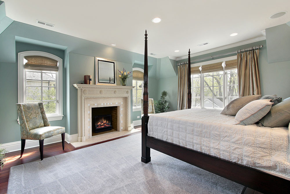 Пример оригинального дизайна: гостевая спальня среднего размера, (комната для гостей) в классическом стиле с зелеными стенами, темным паркетным полом, стандартным камином, фасадом камина из камня и коричневым полом