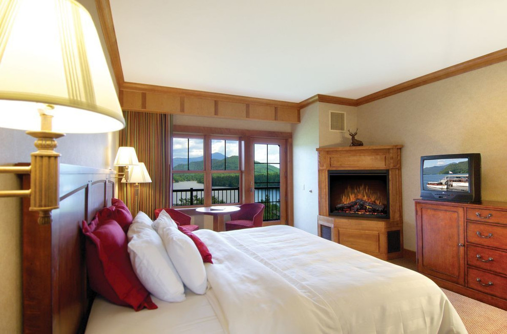 Foto de habitación de invitados de estilo americano pequeña con paredes beige, moqueta, chimenea de esquina, marco de chimenea de madera y suelo beige