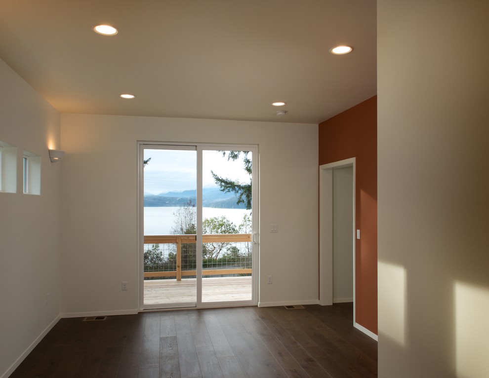 Exemple d'une petite chambre d'amis tendance avec un mur orange, parquet foncé et aucune cheminée.