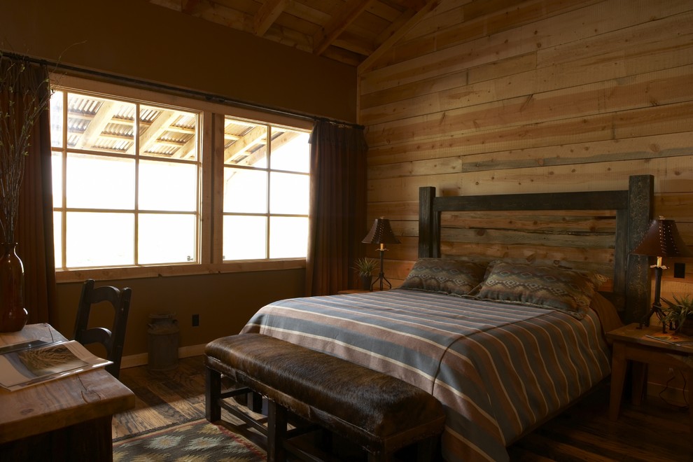 Inspiration for a mid-sized rustic guest medium tone wood floor and brown floor bedroom remodel in Denver with no fireplace and brown walls