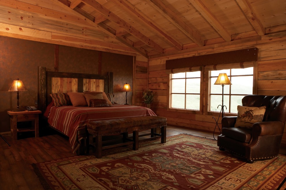 Photo of a large rustic master bedroom in Denver with brown walls, dark hardwood flooring and brown floors.