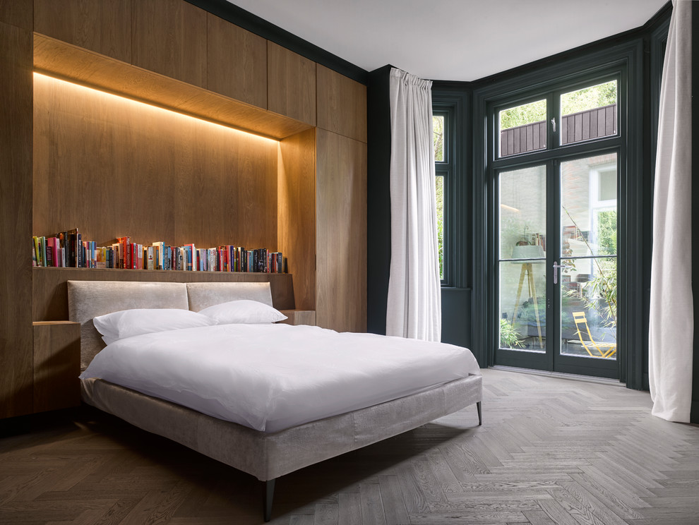 Immagine di una camera da letto minimal con pareti blu, parquet chiaro e pavimento grigio