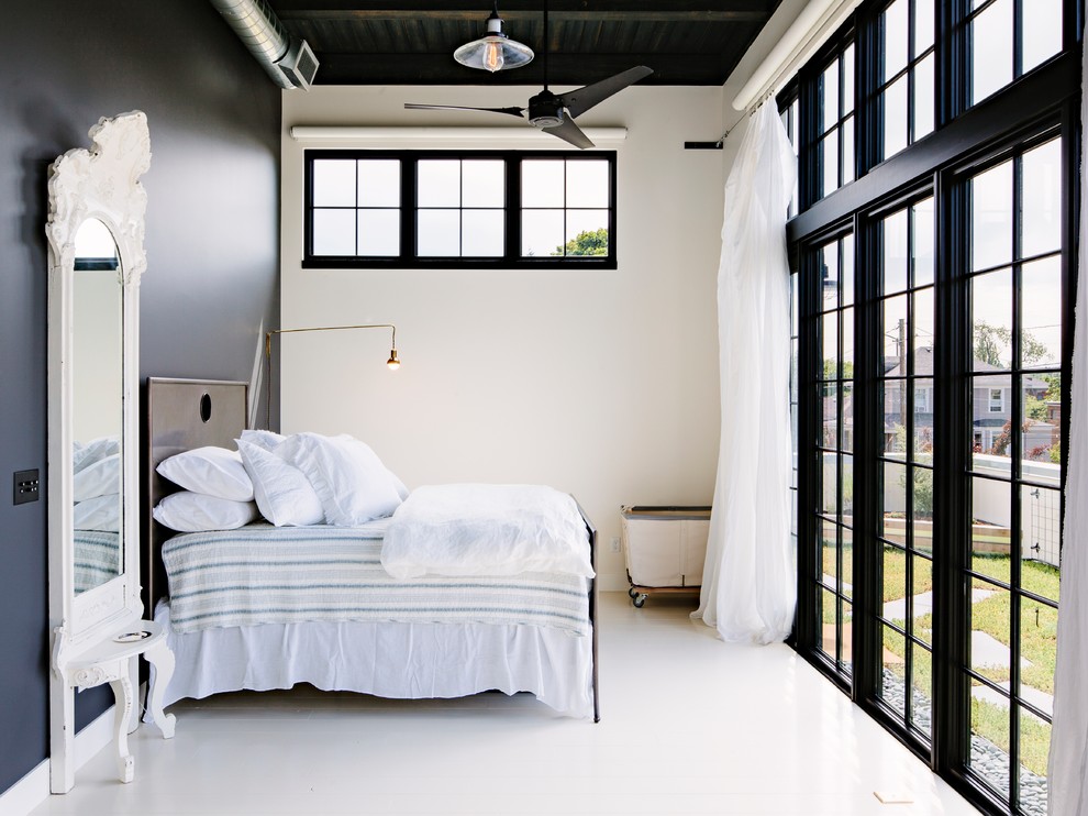 Idées déco pour une chambre d'amis industrielle avec un mur bleu, aucune cheminée et un sol blanc.