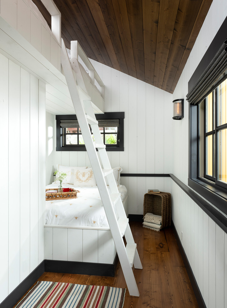 This is an example of a rustic guest bedroom in Other with white walls, medium hardwood flooring, brown floors and a dado rail.