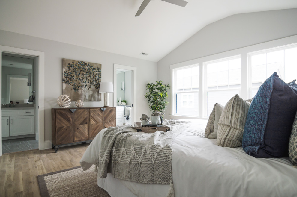 Großes Landhaus Hauptschlafzimmer ohne Kamin mit grauer Wandfarbe, hellem Holzboden und beigem Boden in Charlotte