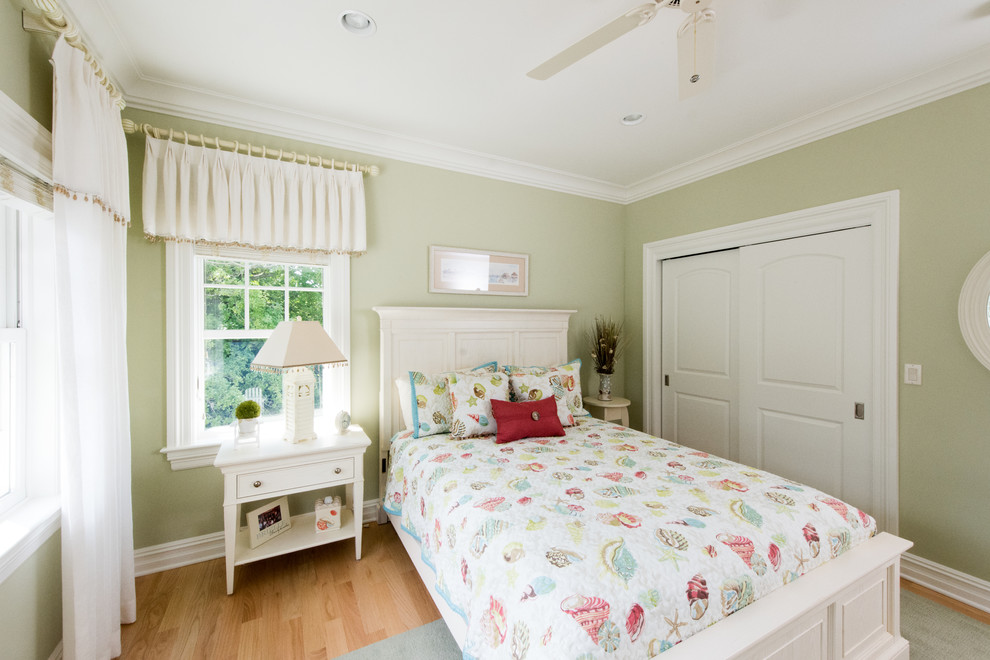 Immagine di una camera degli ospiti costiera di medie dimensioni con pareti verdi e parquet chiaro