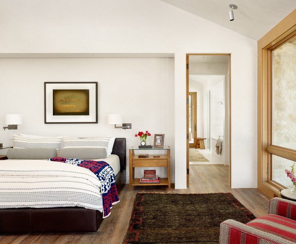 Imagen de dormitorio principal con paredes blancas y suelo de madera en tonos medios