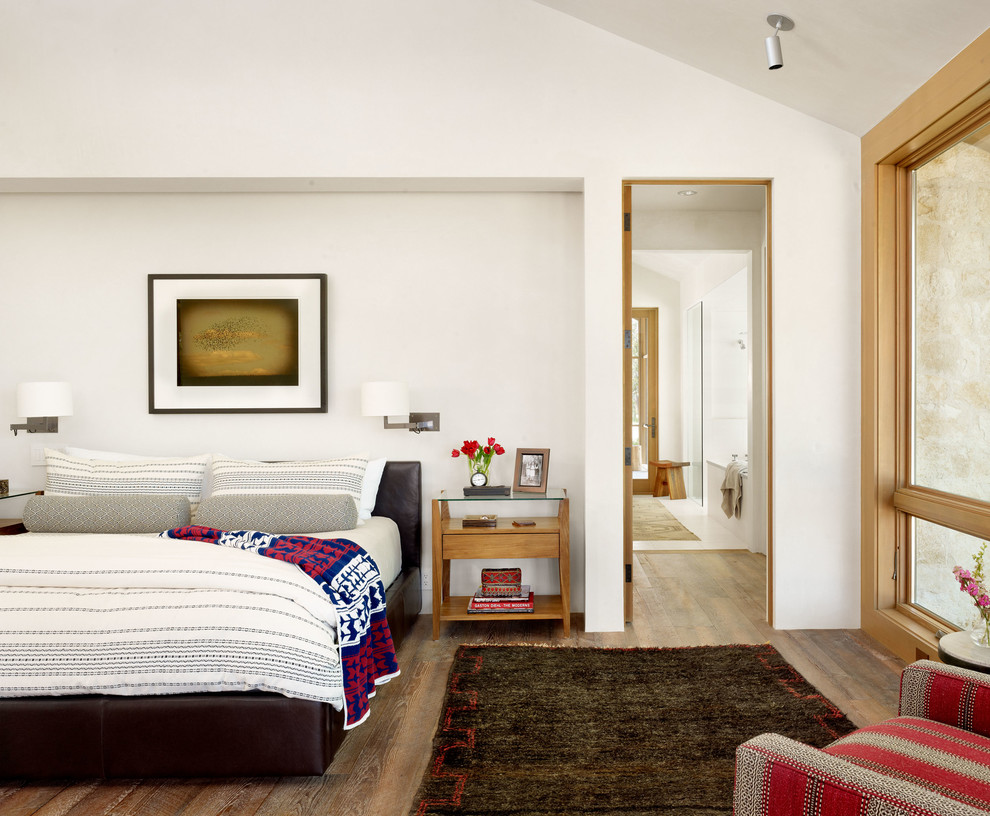 Ejemplo de dormitorio principal de estilo de casa de campo con paredes blancas, suelo de madera en tonos medios y suelo marrón