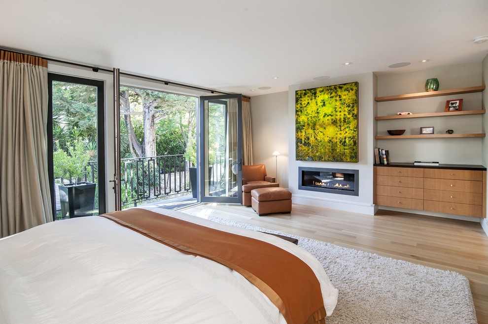 Источник вдохновения для домашнего уюта: большая хозяйская спальня в стиле модернизм с серыми стенами, светлым паркетным полом, горизонтальным камином и фасадом камина из металла