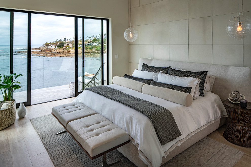 Modernes Schlafzimmer mit weißer Wandfarbe, hellem Holzboden und beigem Boden in San Diego