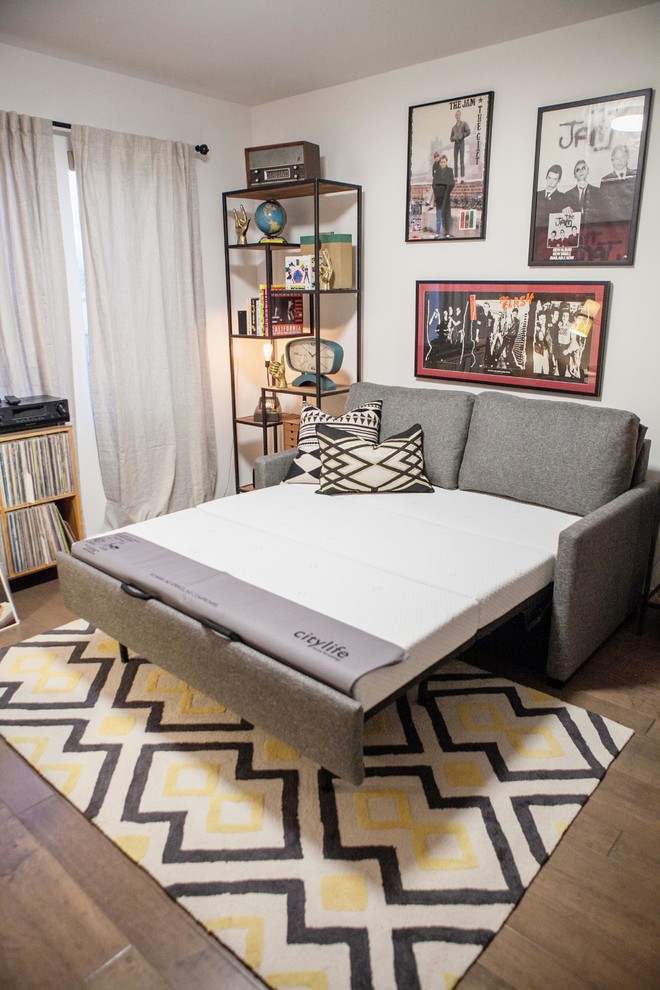 Cette image montre une chambre d'amis vintage de taille moyenne avec un mur blanc et un sol en bois brun.