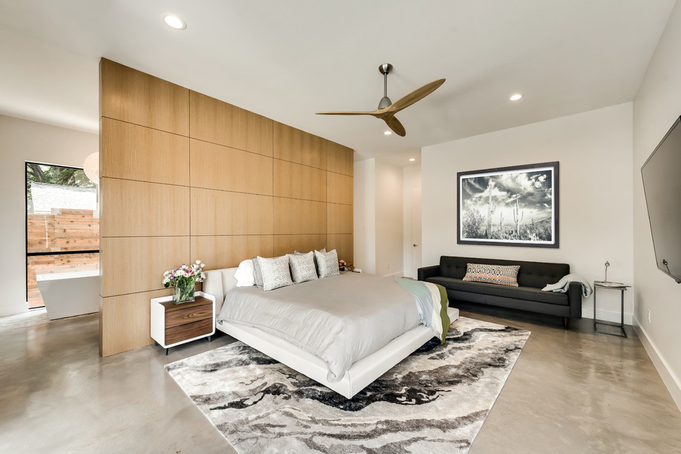 На фото: хозяйская спальня в стиле ретро с белыми стенами, бетонным полом и серым полом без камина